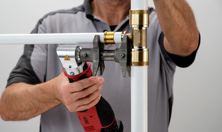 Das Rohr und der Fitting aus dem Rohrsystem TECEflex werden mit einem Axialpresswerkzeug verbunden.