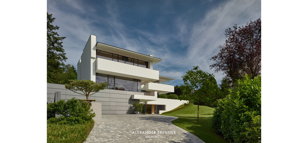 Plastisch-geometrische Kuben treffen auf sanft geschwungene Rasenkanten. Foto: © Alexander Brenner Architects